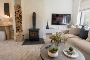 The Living Room: cosy up in front of the log burner and watch a film whilst snuggled on the comfortable sofas.