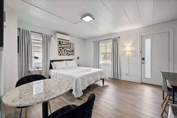 Modern studio with queen bed, Smart TV, works pace, and kitchen