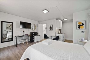 Modern studio with queen bed, Smart TV, works pace, and kitchen