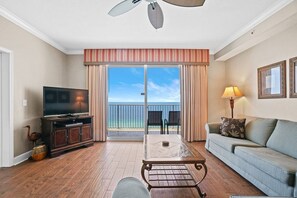Open concept living area with stylish furnishings TV balcony access and sofa bed
