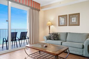 Open concept living area with stylish furnishings TV balcony access and sofa bed