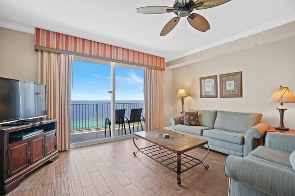 Open concept living area with stylish furnishings TV balcony access and sofa bed