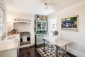 The open-plan kitchen and dining area combines a classic French aesthetic with modern touches, perfect for relaxed meals at home.
