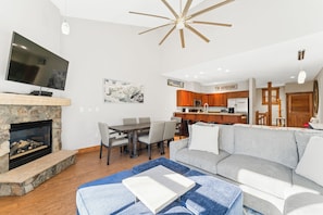 Living area with mounted flat screen TV, gas fireplace and access to the private balcony.