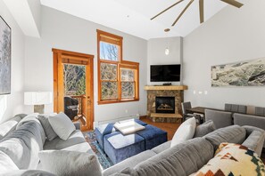 Living area with mounted flat screen TV, gas fireplace and access to the private balcony.