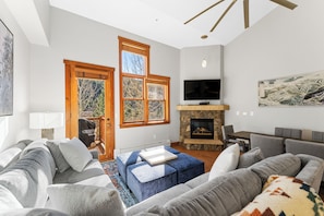Living area with mounted flat screen TV, gas fireplace and access to the private balcony.