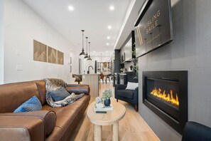 Living room with a gas-lit fireplace, luxurious seating options & a Smart TV.