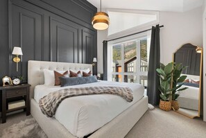 Primary bedroom (located on the top floor) with a king bed, closet, blackout blinds & a private ensuite full bathroom.