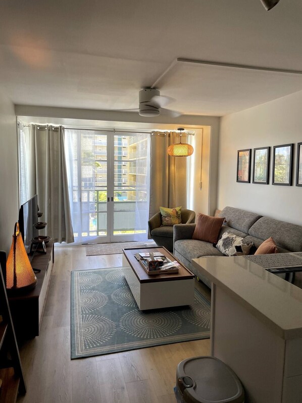 comfortable living room area with amenities with large smart TV, comfortable sofa and lift up top coffee table.