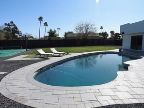 Savor the backyard oasis with pool, basketball court and putting green