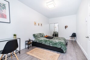 Chic minimalist bedroom featuring a harmonious blend of white, black, and wood tones for a stylish and calming retreat.