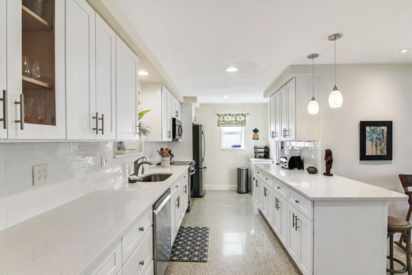 The bright, cheerful kitchen offers ample space & all the comforts of home