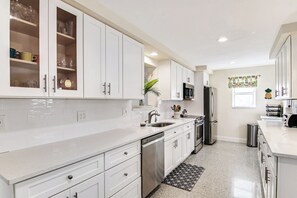 The bright, cheerful kitchen offers ample space & all the comforts of home