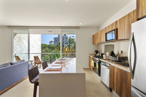 Fully equipped kitchen & dining area with balcony access.