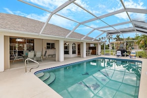 Pool with lanai sitting area and canal view