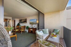 Sip drinks and enjoy panoramic views of Maui's coastline and gardens from this cozy lanai with comfortable seating and tropical decor.