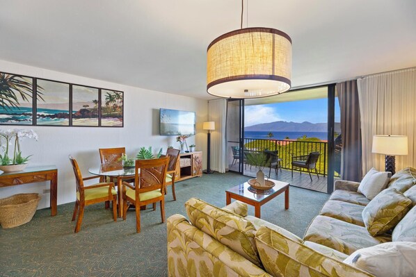 Unwind in the spacious living room with ocean views, lush tropical decor, and modern amenities, creating a relaxing retreat in paradise.