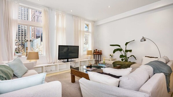 Bright and airy living room with large windows offering city views