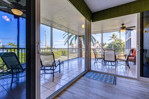 Enjoy a meal or drinks on the screened porch while taking in the serene water views, creating the perfect setting for relaxation.