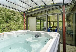 Covered all-season 6-person hot tub just off the White Oaks Haven three-season sun porch