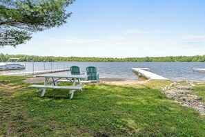 At the private lake access & dock for Woodland Pines Cottage, featuring a canoe, a picnic table, and two (2) Adirondack chairs for guest use. This area on the eastern shore of Upper Scott Lake is located just one (1) mile away from our home.
