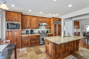 Gourmet Kitchen: Equipped with luxurious wood cabinetry, granite countertops, and modern appliances