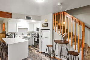 Outfitted with sleek stainless steel appliances, a Keurig coffee maker, and a convenient bar seating area perfect for casual dining or shared meals.