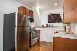 Fully Equipped Kitchen – Compact but stylish with all the essentials, including a fridge/freezer, stove, and microwave, paired with stainless steel appliances and granite countertops.