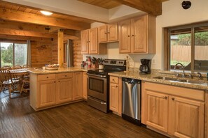 Cook in style with this fully equipped, cabin's kitchen featuring sleek granite countertops and brand-new stainless steel appliances