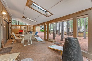 Unwind on the covered backyard patio, complete with a grill, seating for 6, and a game of corn hole—perfect for enjoyable afternoons, rain or shine.