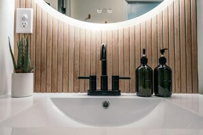 Vanity sink with hand soap and lotion.