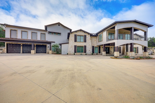 This stunning Mediterranean-style custom estate spans 7,400 sq. ft. with 5 bedrooms, an attached garage, a spacious driveway, and is beautifully situated on a vast, wooded countryside.