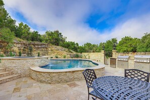 Our expansive back patio features two BBQ grills and a cozy dining area with a table and chairs, perfect for enjoying meals outdoors in a relaxed, alfresco setting.