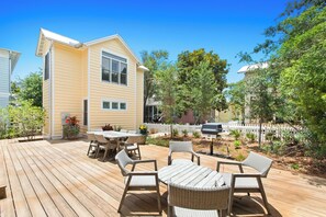 Expansive backyard with deck, outdoor dining, and grill