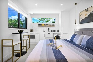 Bright, cozy studio with modern kitchen, stylish decor, and natural light.