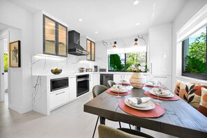 Spacious, modern kitchen with a stylish dining area and ample natural light.