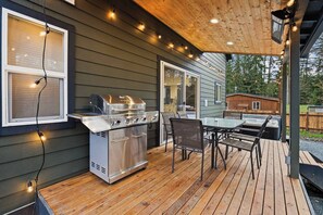 A large outdoor grill for your enjoyment. Grilling tongs and turner available in the kitchen. String lights add to the festive feel