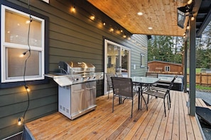 A large outdoor grill for your enjoyment. Grilling tongs and turner available in the kitchen. String lights add to the festive feel