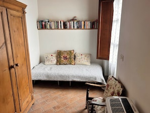 An extra day-bed in the primary bedroom, suitable for  your child or small adult, under take-a-book-leave-a-book library and with its own access to the outdoors...