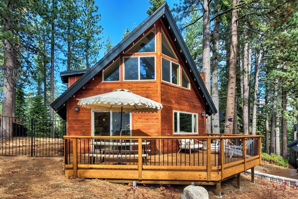Front of the cabin, nestled among towering pine trees for a true mountain retreat.