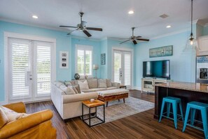 Bright and airy living space with plush seating and a large TV.