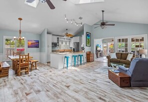 Kitchen and open floor plan living area with skylights