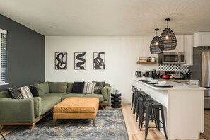 Relax in a modern living room that flows seamlessly into the kitchen.