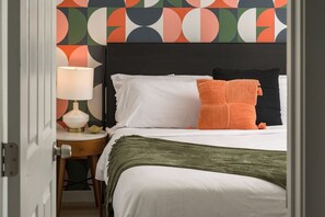 King bedroom with bold decor and cozy bedding.