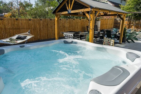 Enjoy the full outdoor experience with hot tub, fire pit, and seating.