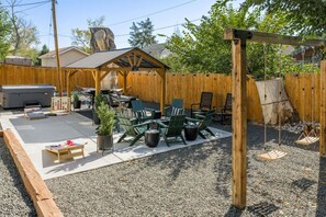 Expansive backyard retreat with hot tub, fire pit, and pergola.