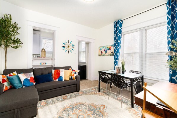 A cozy haven, bathed in natural light, showcasing a blend of modern and rustic charm.  📺