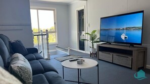 Upstairs living room with comfy sofa and large screen TV