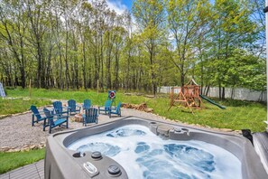 Enjoy ultimate relaxation in the outdoor hot tub, perfectly positioned to overlook the pool and cozy fire pit area—ideal for unwinding under the stars!