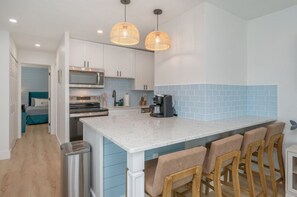 Where comfort meets function: a welcoming countertop with chairs and a sneak peek of the kitchen.